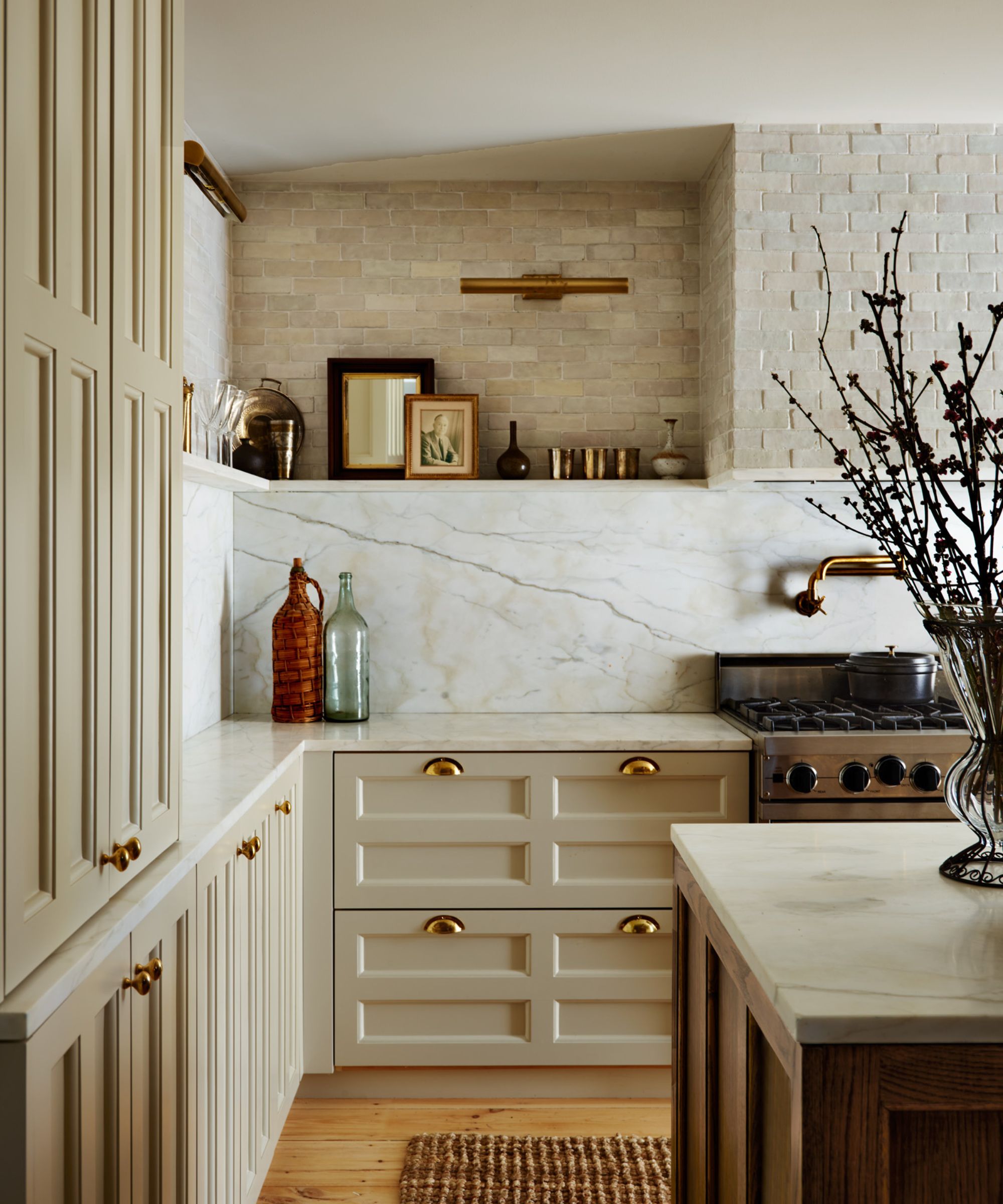 modern rustic kitchen with warm neutral cabinets and marble wall