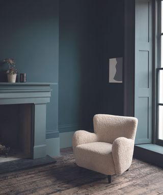 sitting room with occasional chair and blue walls and fireplace
