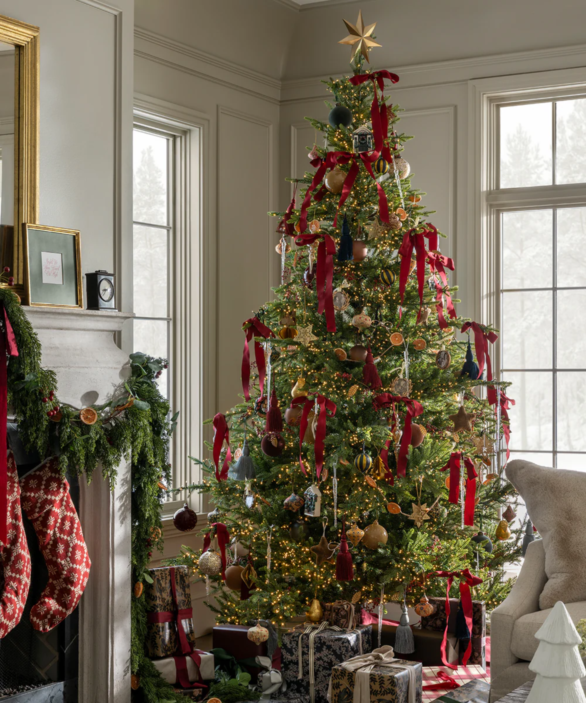 a Christmas tree display with red bows hanging from each branch and presents under the tree
