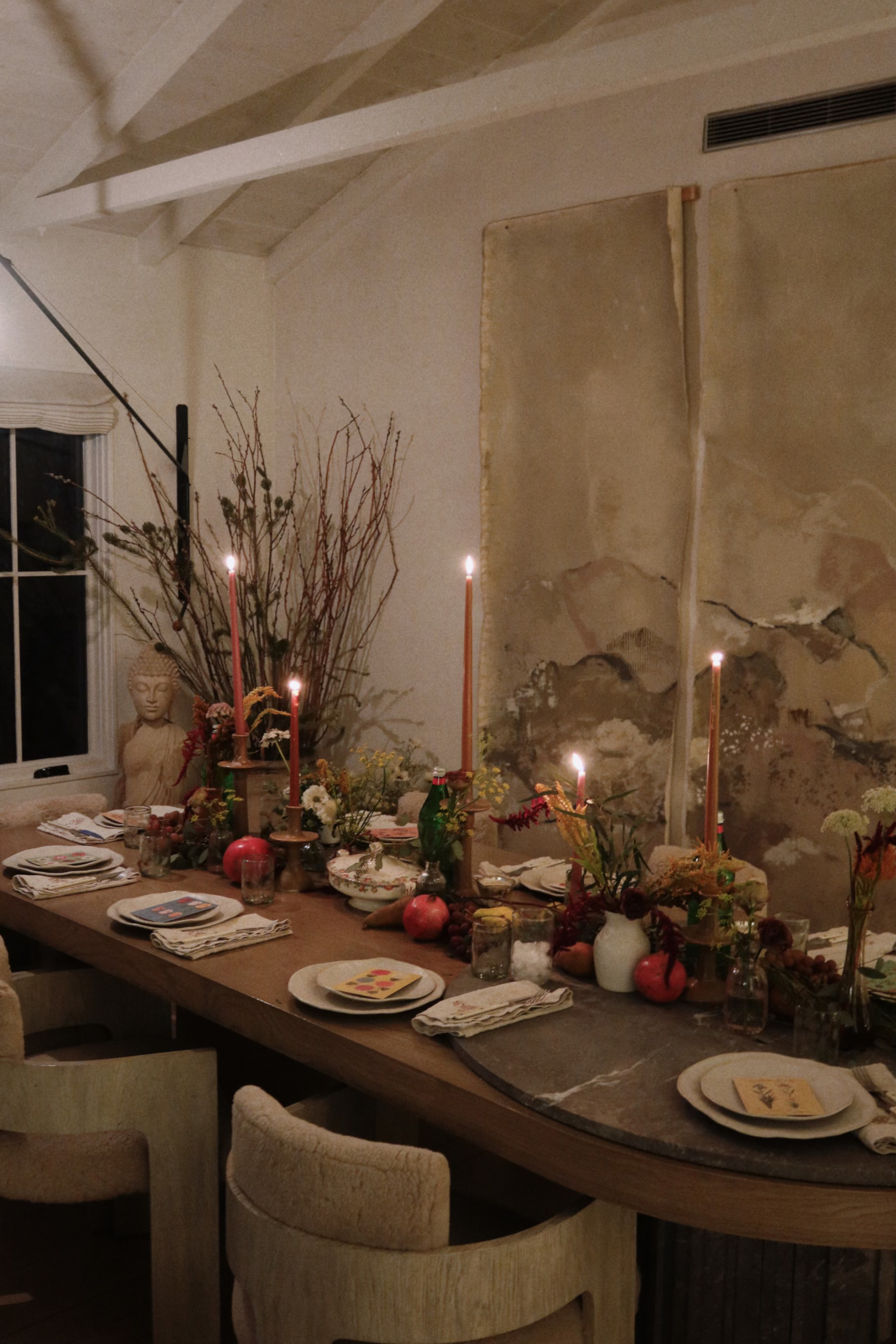 A table laid for Christmas with taper candles and seasonal foliage
