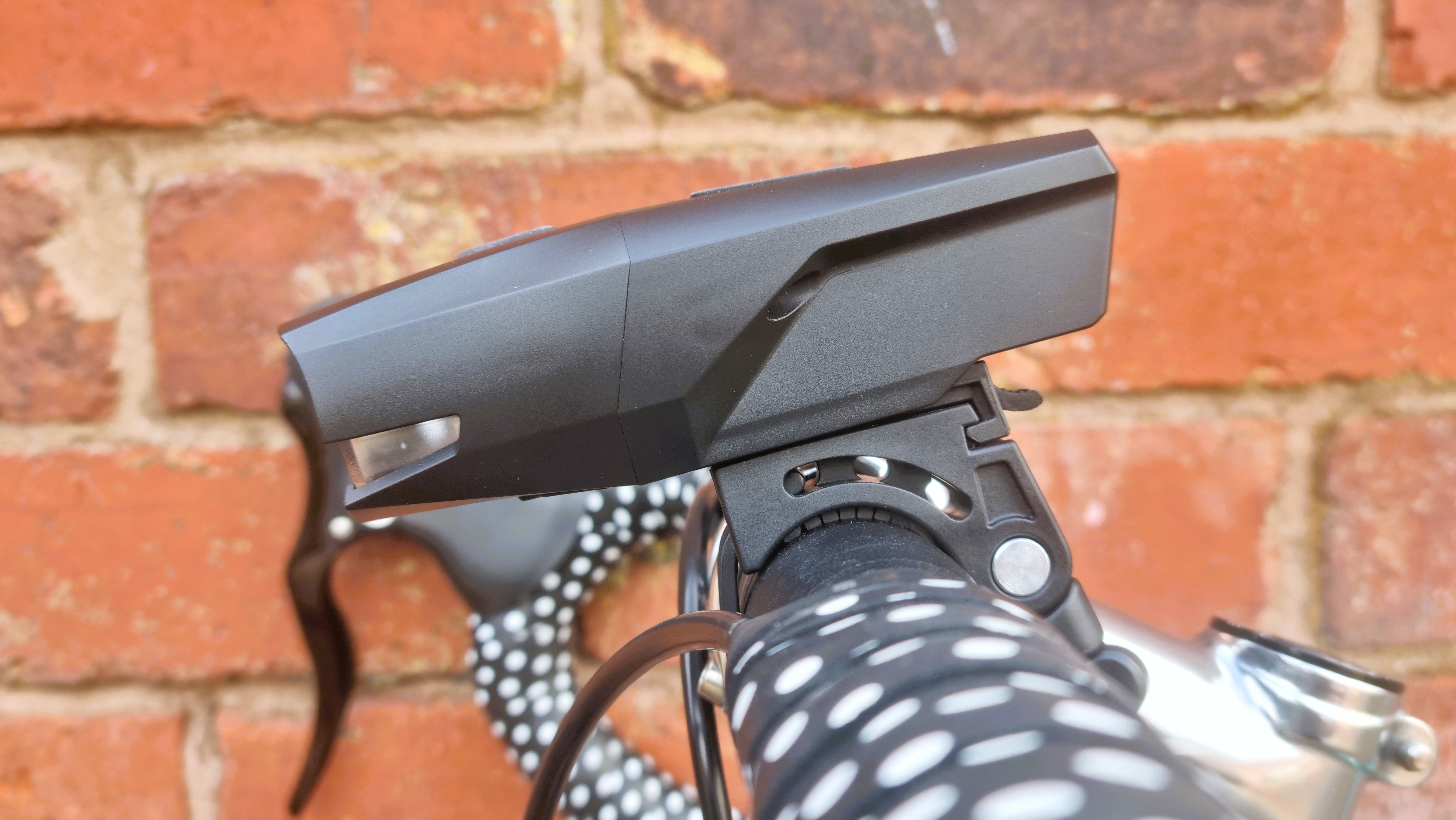 A close up of the PDW City Rover 700 front light, mounted to a handlebar and seen from the side