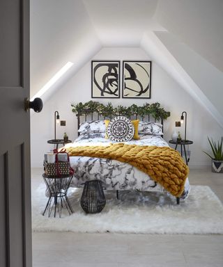 a loft bedroom with symmentrical eaves, artwork and bedside lighting - Malcolm Menzies