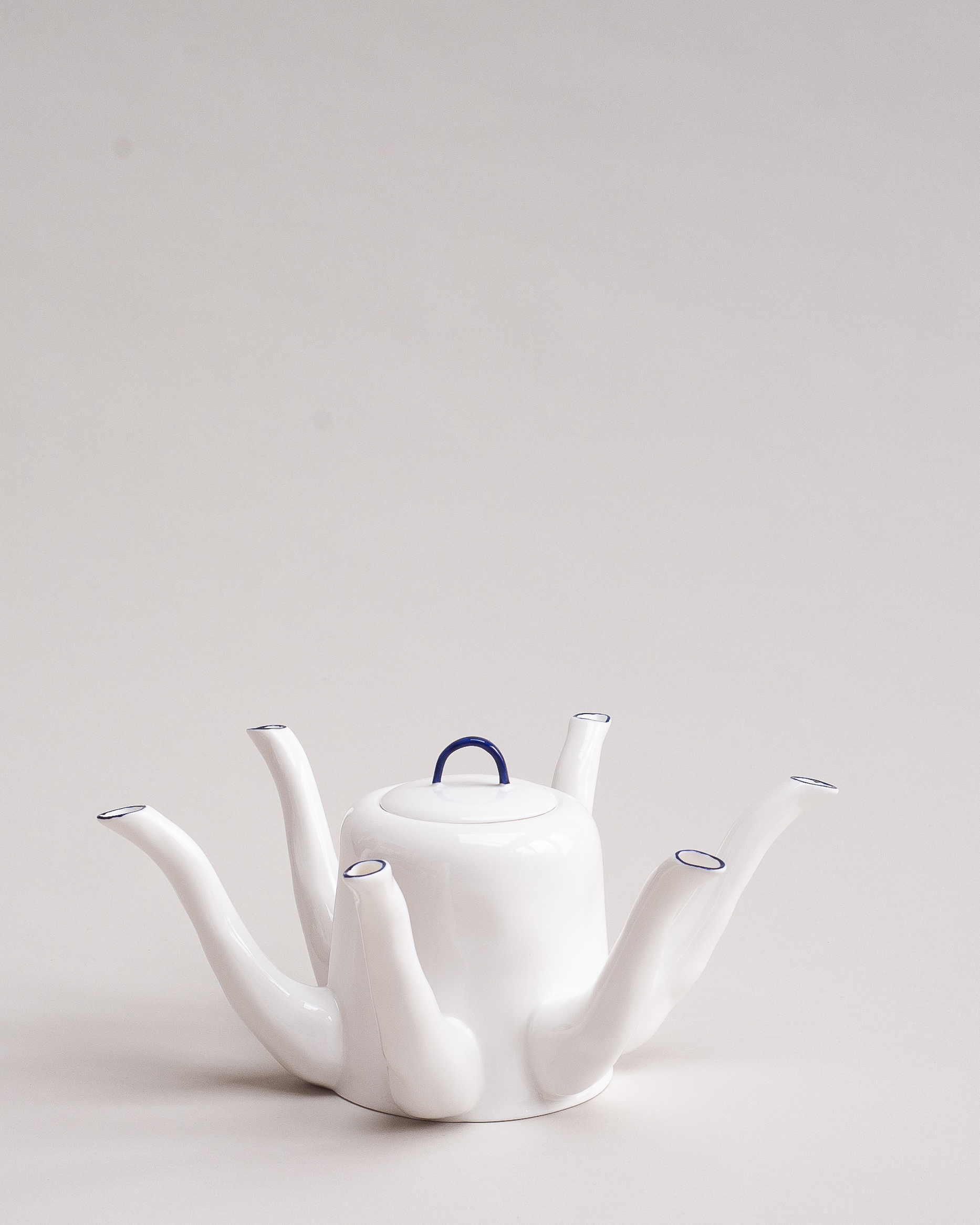 White bone china teapot with cobalt blue-painted handles and spouts