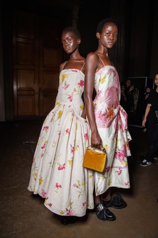 two models wearing floral dresses from erdem at the spring/summer 2025 london fashion week show