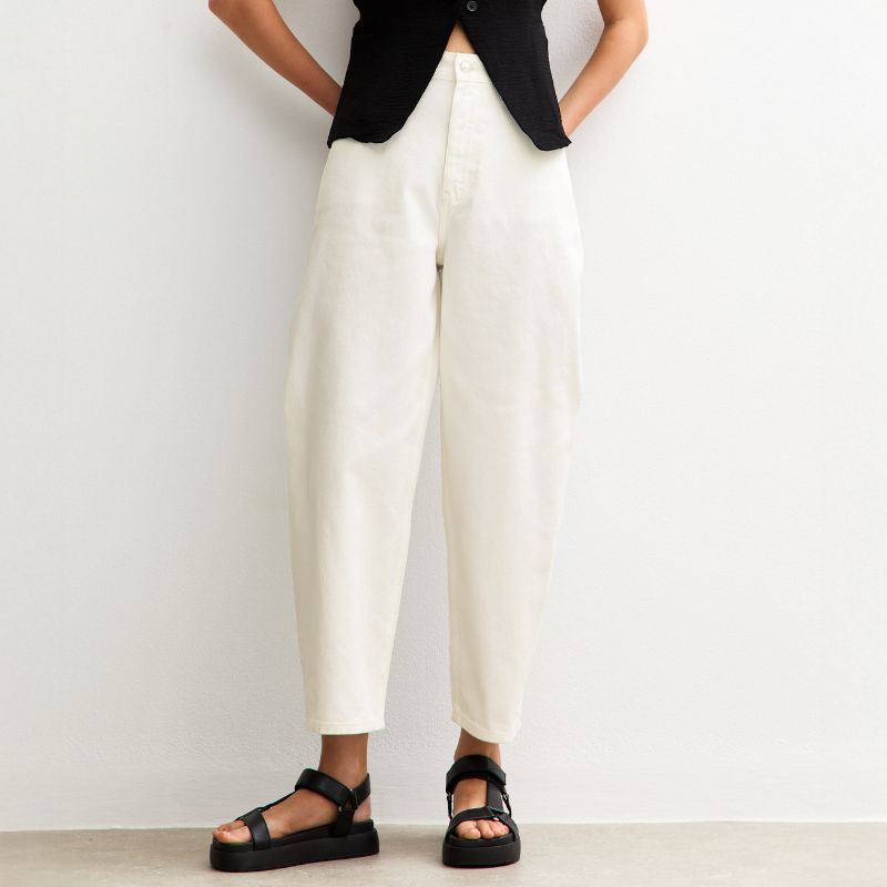 A model wears white barrel leg jeans