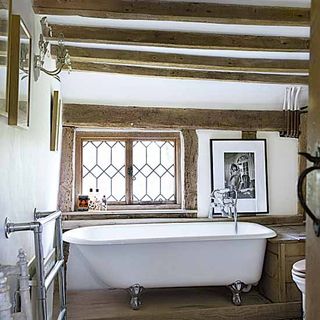 bathroom with white walls and wooden beams