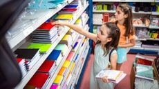 Little girls trying to decide which notebook to buy while back-to-school shopping