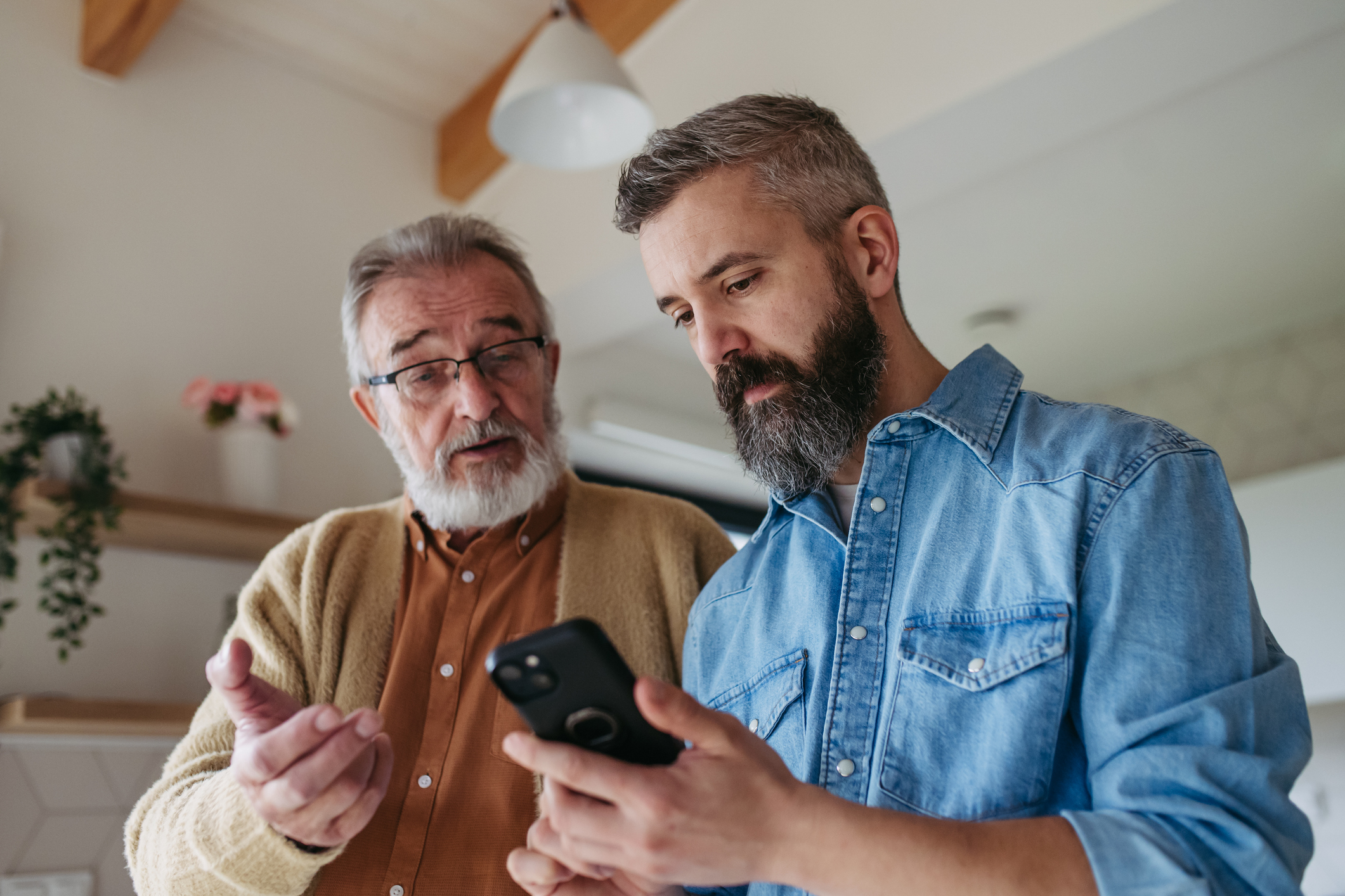 Father and son looking through phone. 