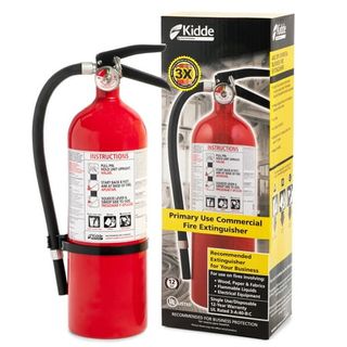 A red Kidde Fire Extinguisher with a black handle and hose. Next to a black and yellow cardboard box. 