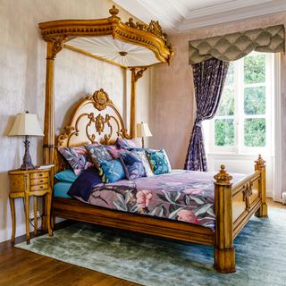 ornate wooden bed with purple floral bedding