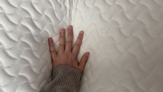 A close-up of a hand pressing into the Tempur-Pedic Tempur-Cloud Pillow, demonstrating the pressure relief