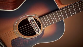 Close-up shot of the soundhole and pickup of the Guild M-240E Troubadour
