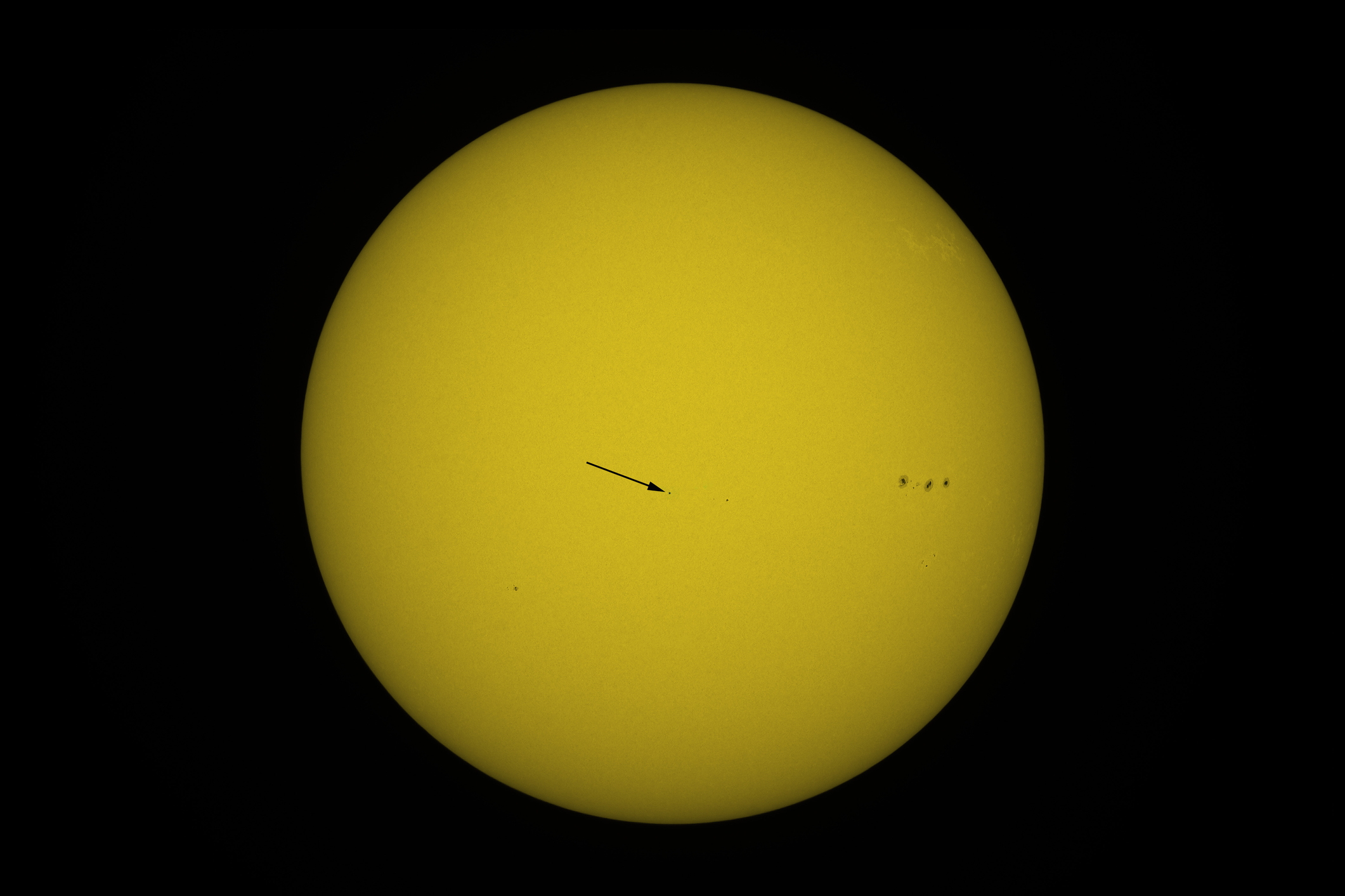 An exceptionnal image showing the chinese space station Tiangong crossing the disk of the Sun on december 31 2021. The arrow shows the position of the station due to its very small apparent size. On the disk of the Sun we can also see sunspots (on the right the sunspots AR2916). Image taken by the author from Seine et Marne with an amateur telescope. Arrow drawn by the author.