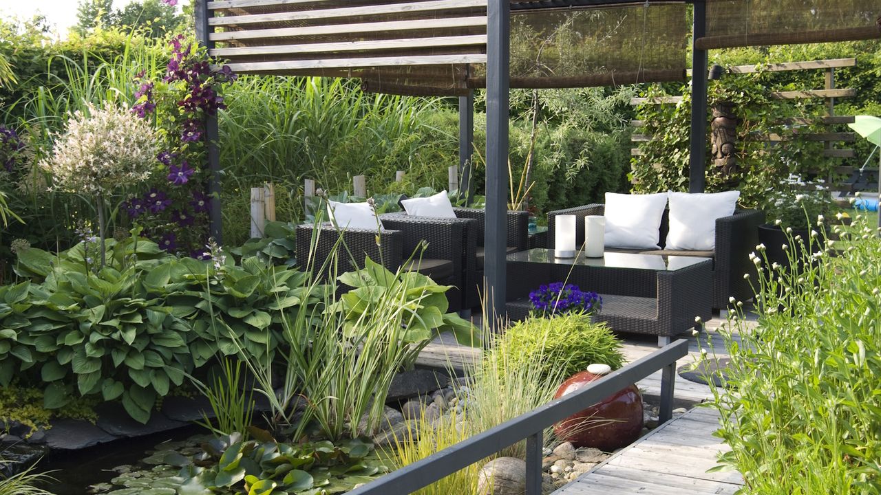 Modern patio garden lounge with a pond and outdoor sofas