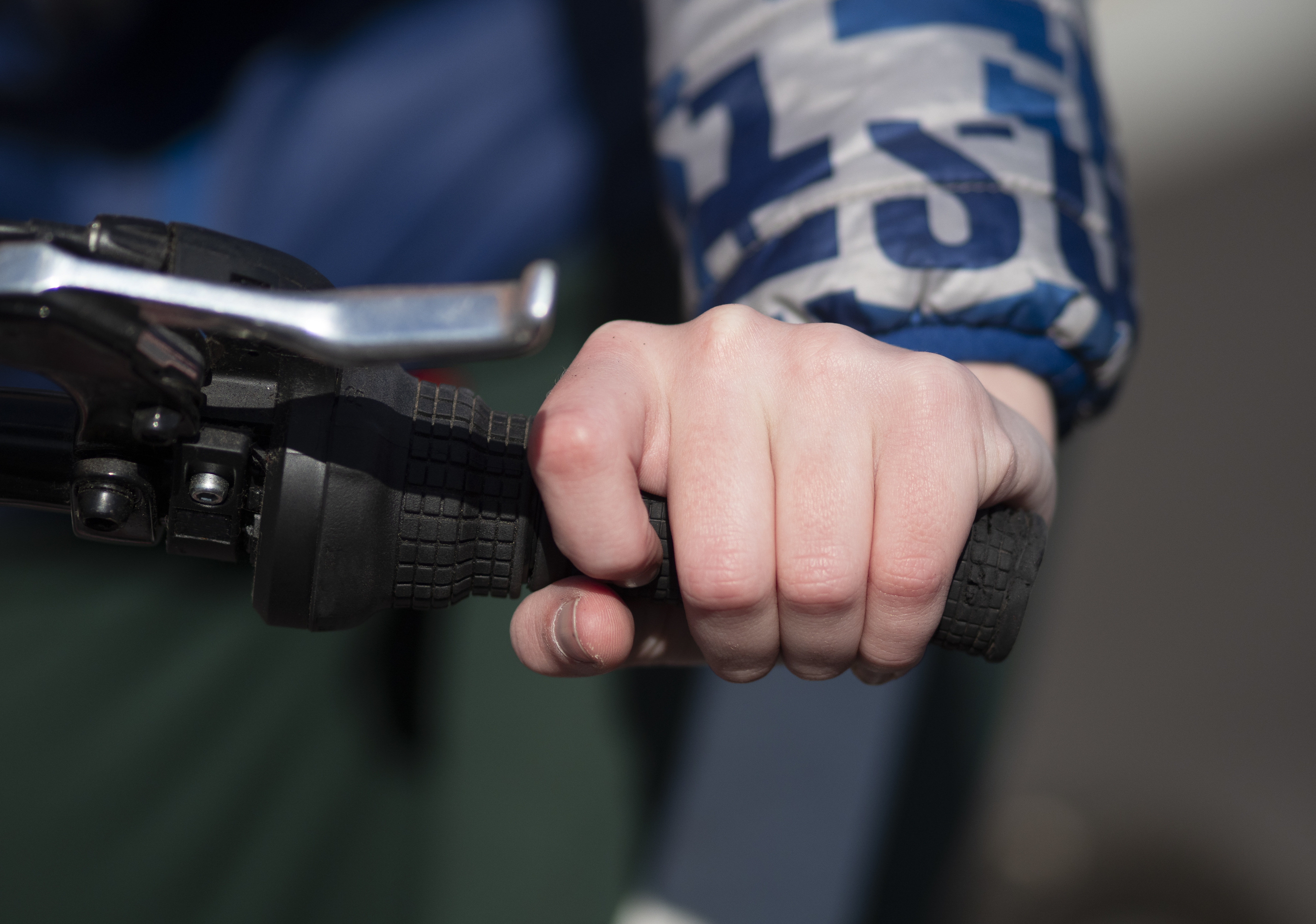Child's hand grips a handlebar