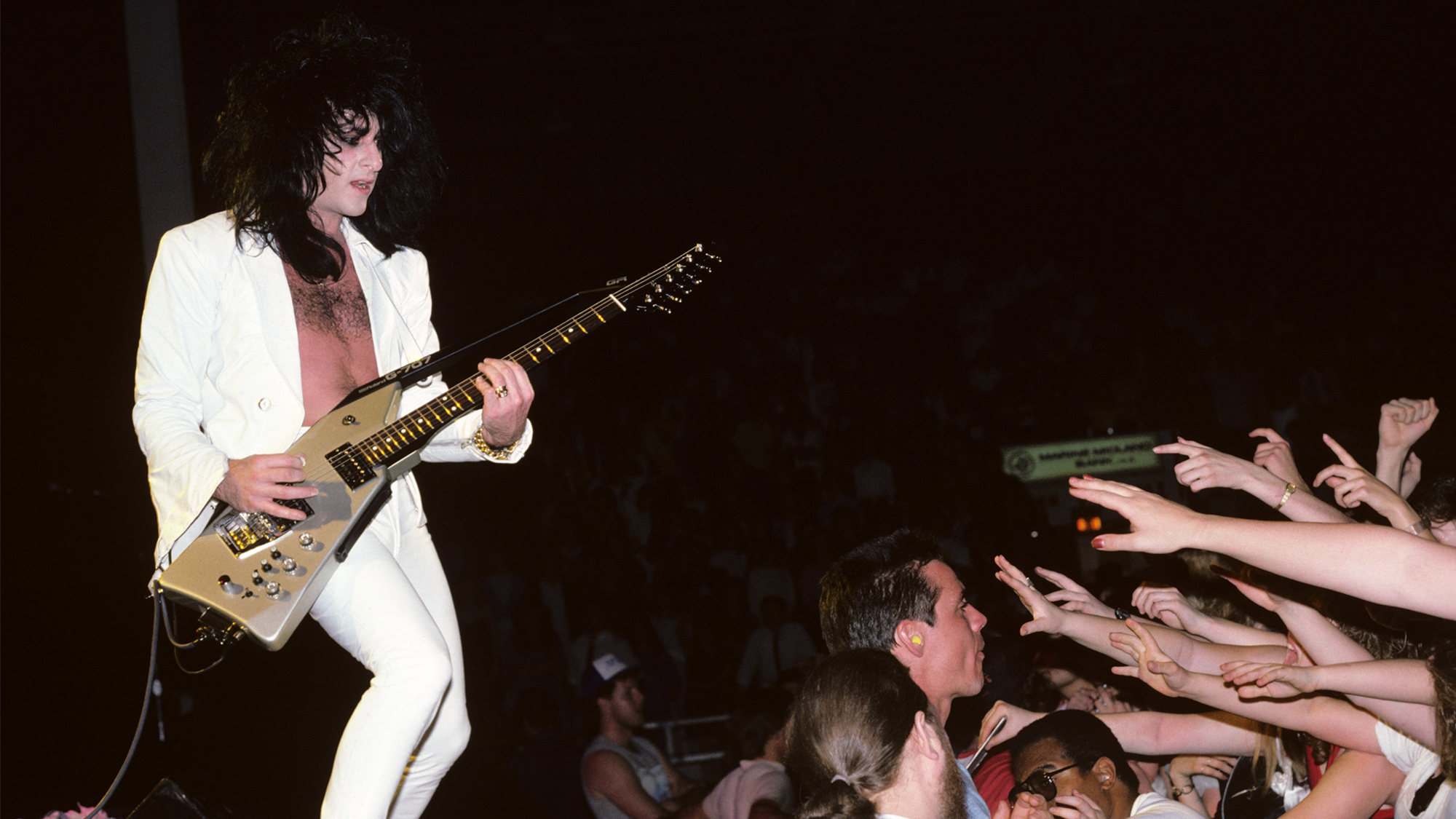 Steve Stevens performing live onstage with Billy Idol and playing Roland GR-707 guitar synthesizer as fans reach out from the audience, April 12, 1987
