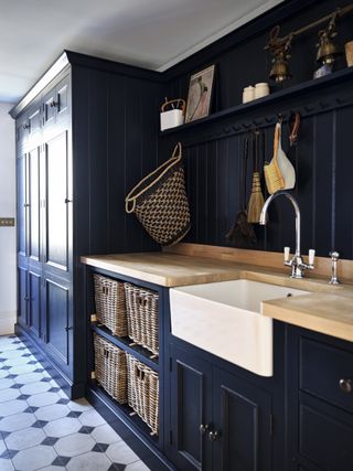 dark blue utility room with belfast sink and floor to ceiling storage