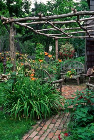 rustic garden pergola with brick path and wooden seating