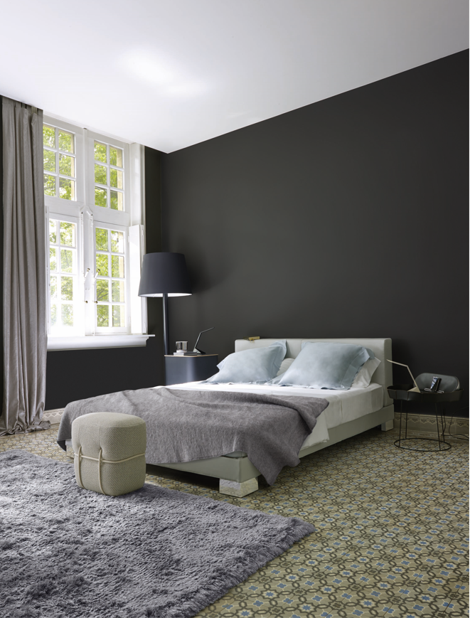 A bedroom with a carpet and layered on top, a rug