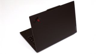 A black laptop sitting against a white background, viewed from the back with the lid open.