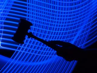 A photo of a silhouette of a hand holding a gavel is in the foreground, with a futuristic mesh of blue lines in the background