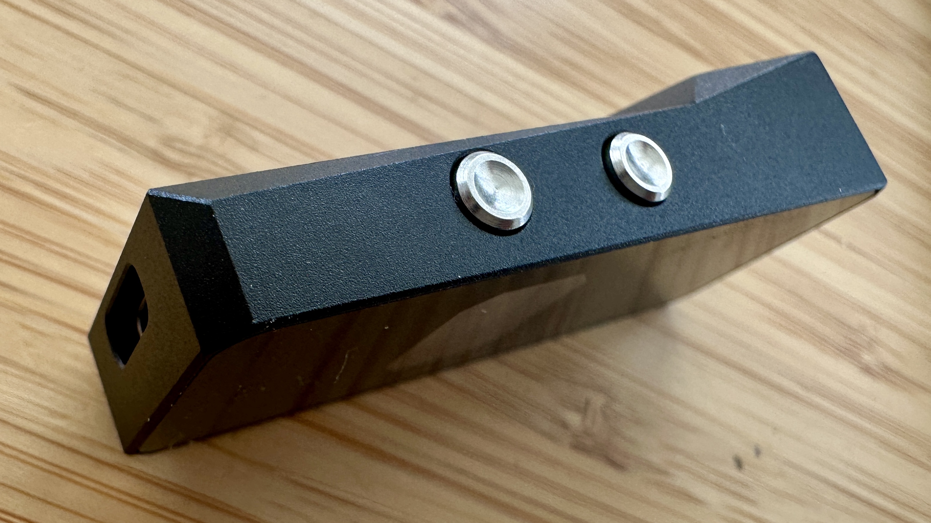 Side panel of the Campfire Audio Relay headphone DAC on a wooden surface