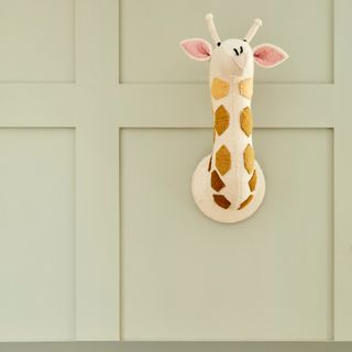 Sage green wall with outward giraffe head