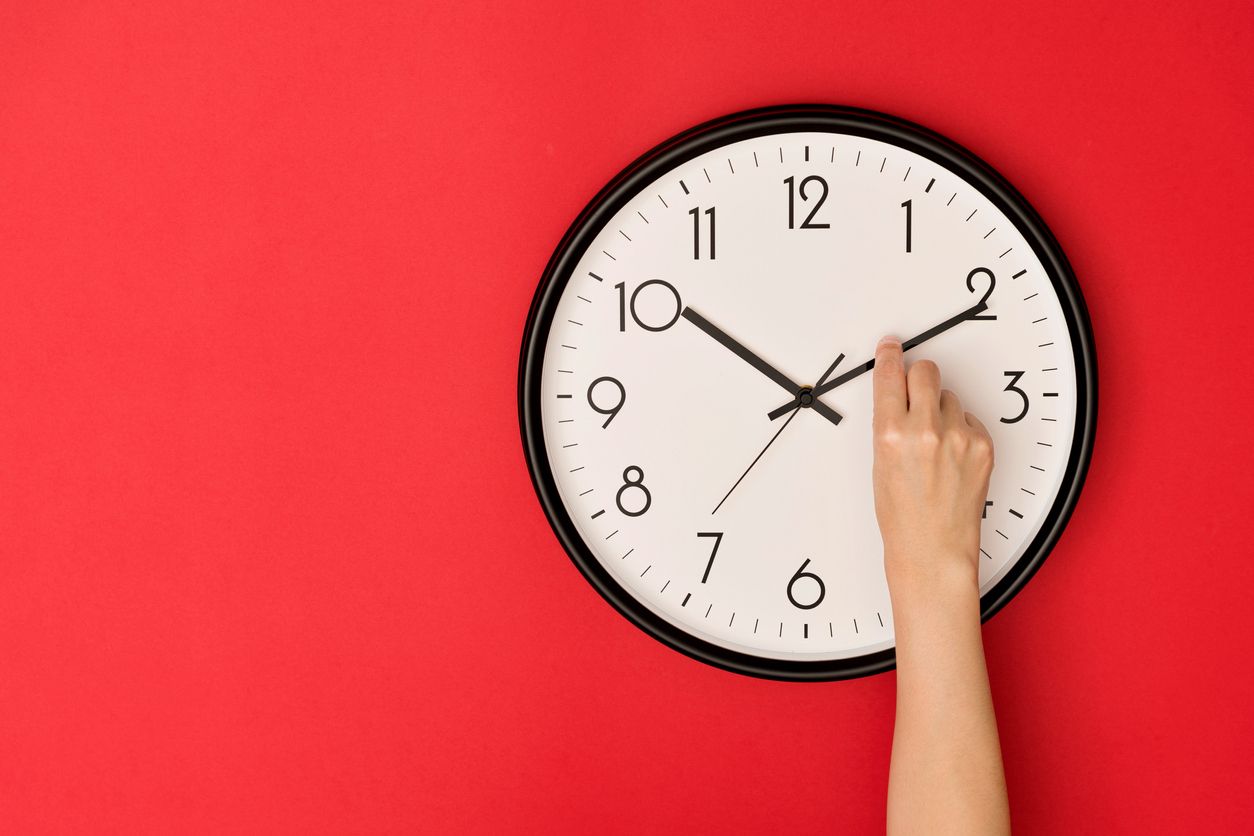 Person adjusting clock.