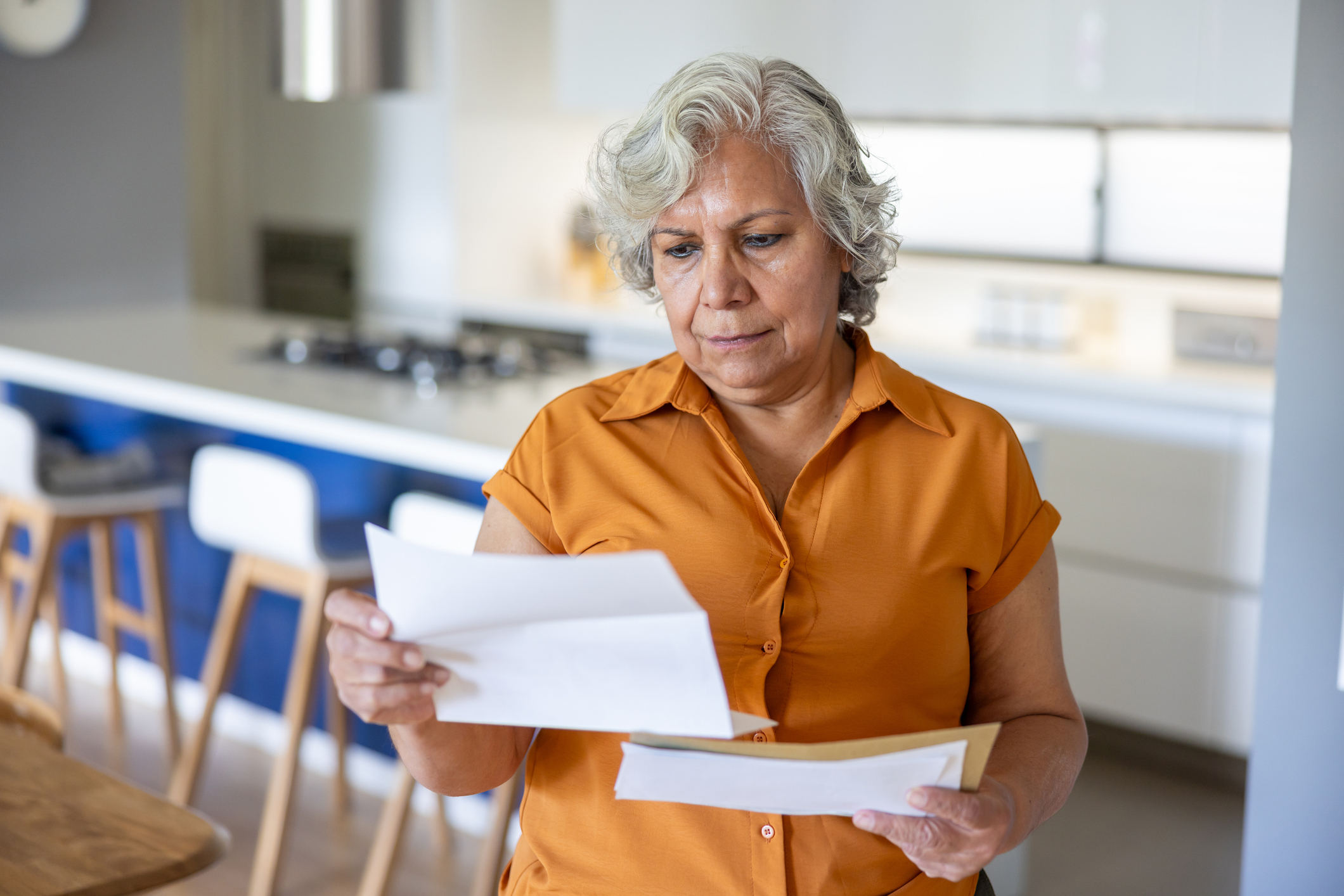 A woman reading a letter from HMRC about an inheritance tax investigation