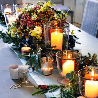 candle display with berries and conifer cones
