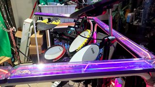 The Govee x Evangelion lighting kits set up on a wall and around a desk and drum kit with various RGB lighting modes enabled.