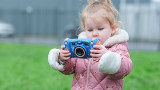 Small child holding toy camera