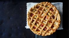 Rhubarb and apple pie with pastry lattice, on black marble background
