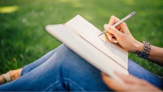 How to manage anxiety and how to stop worrying: a person writes in a mood journal