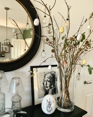 easter tree in a vase on a sideboard in a hallway