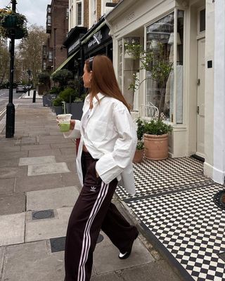 white shirt outfits: @rebeccaferrazwyatt_ wears a white shirt with track pants