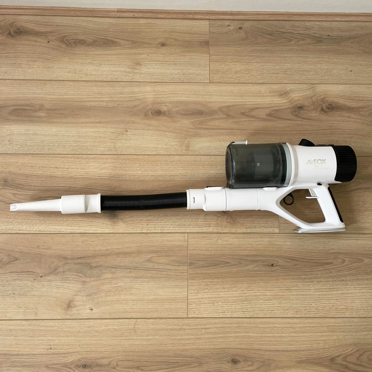 Gtech AirFOX Platinum Cordless Vacuum with extendable tube on it laying on the floor