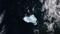 Satellite photo of an iceberg covered with vibrant blue stripes in the middle of the ocean