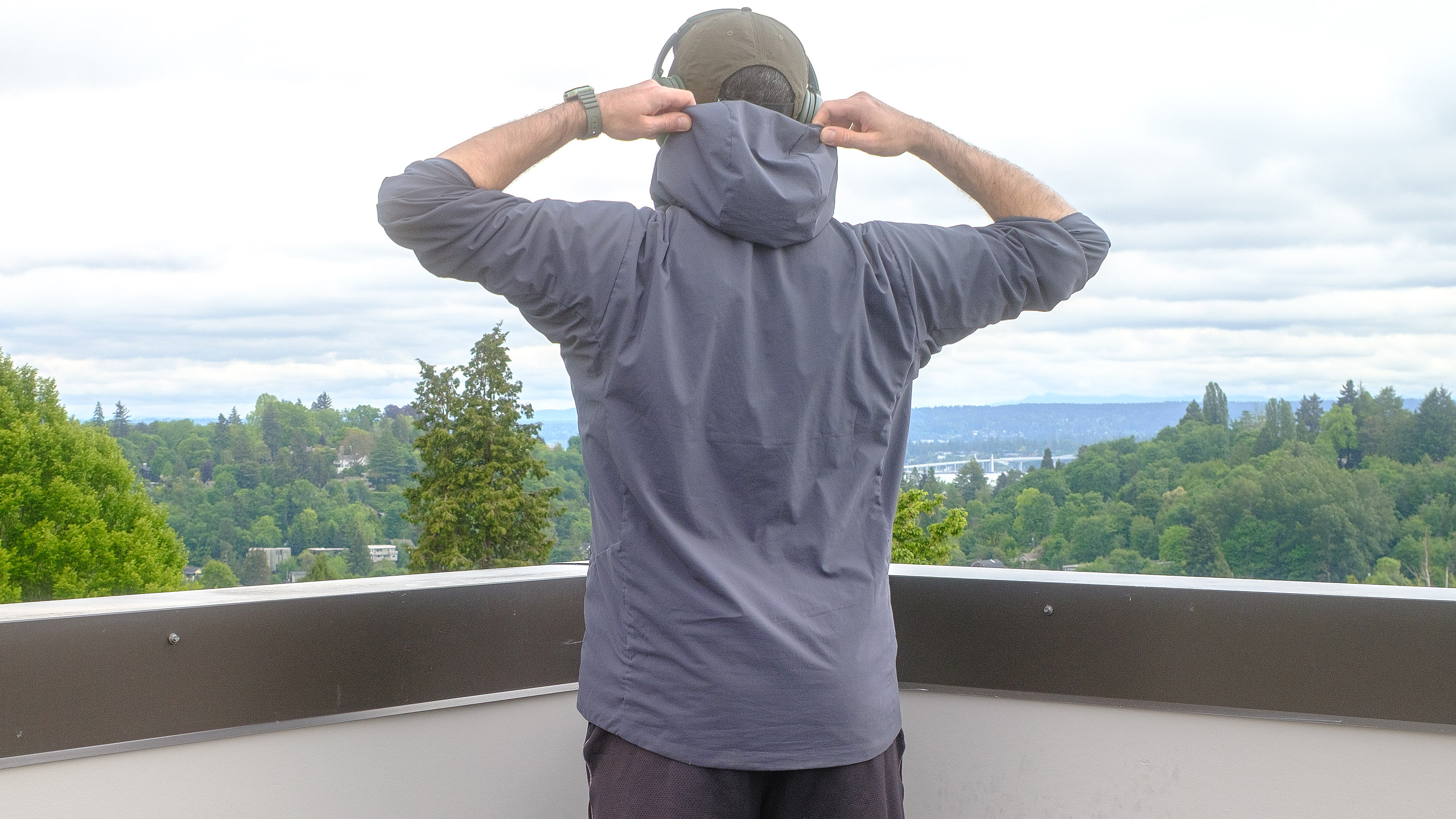 Senior writer Dan Bracaglia wearing the Patagonia Nano-Air Ultralight in grey/blue on the roof of his home in Seattle, Washington with trees and overcast skies in the distance