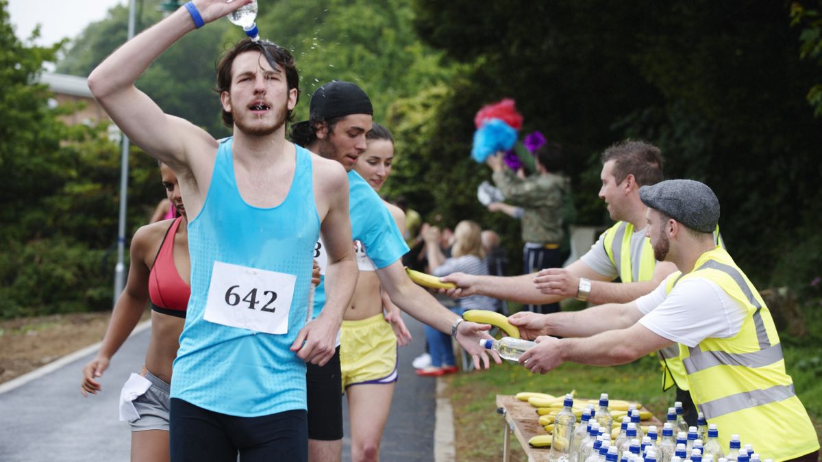 Runners taking water and bananas from aid station during a race