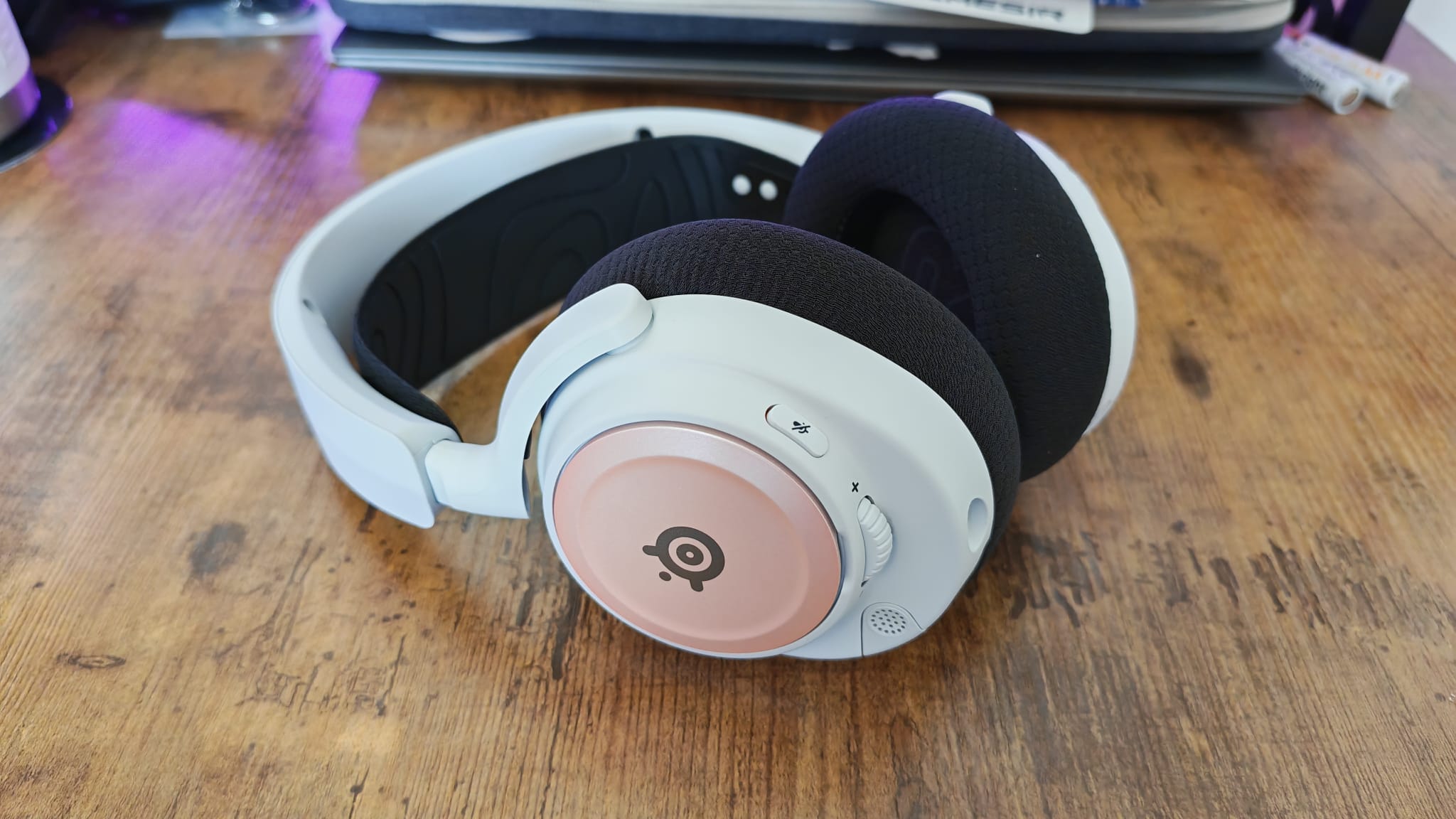 The SteelSeries Arctis Nova 7P with black and pink accessories