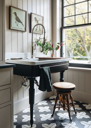 Farmhouse bathroom with cream shiplap walls, monochrome tiled floor and statement dark wood sink