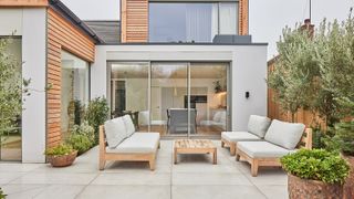 A paved patio in front of glass sliding doors of a home renovation project