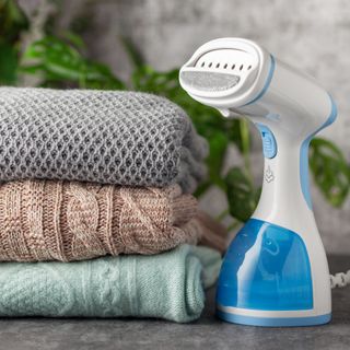 Portable handheld clothes steamer on tabletop