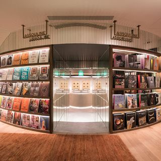 Assouline outlet in the JNĉQUOI luxury restaurant. To the left and right there are different coffee table books displayed on shelves, with different themes - fashion, design, travel, and lifestyle.