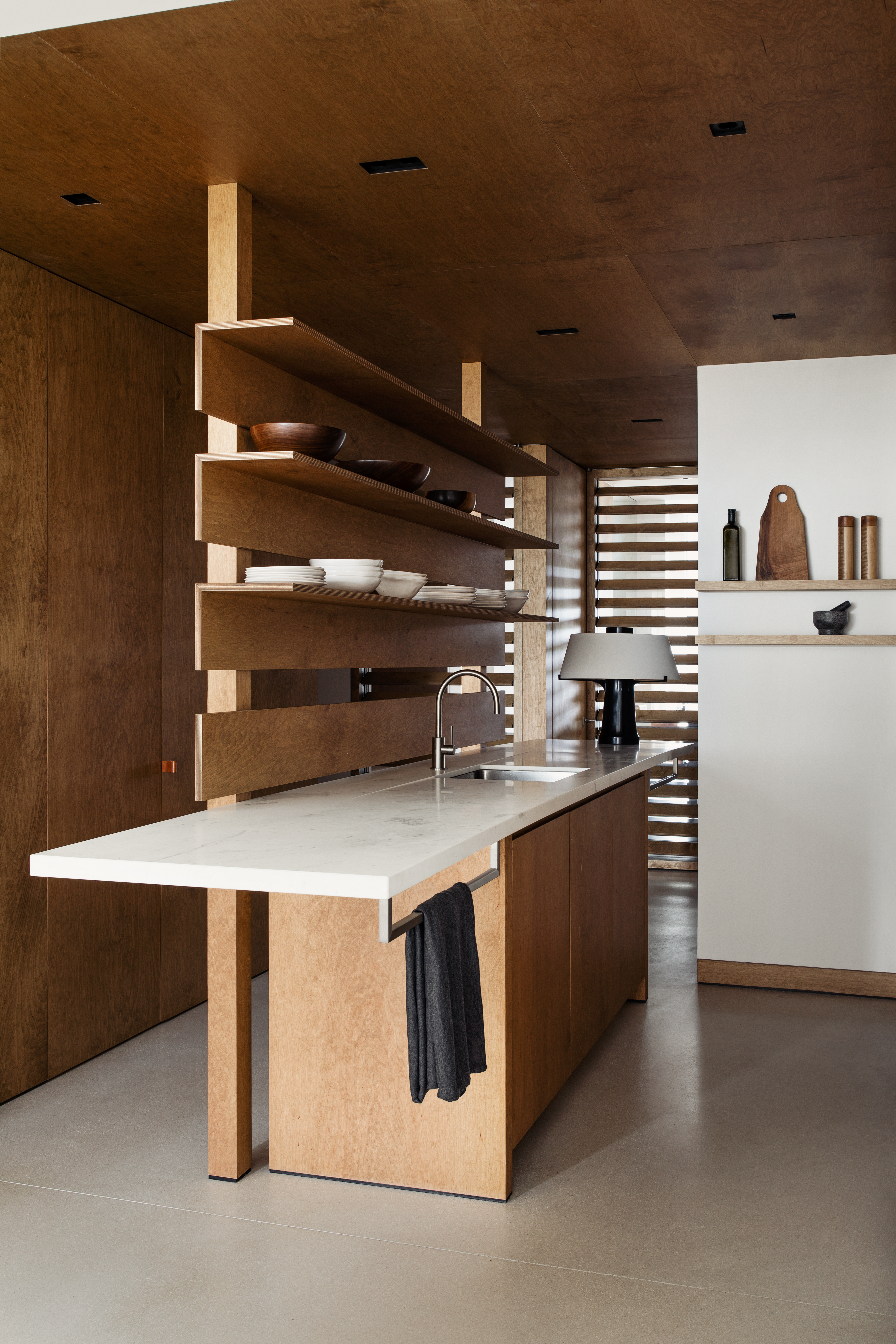 A kitchen with wooden base, and marble base, and storage above it
