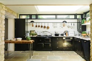 Farmhouse kitchen with glossy black vintage cabinets