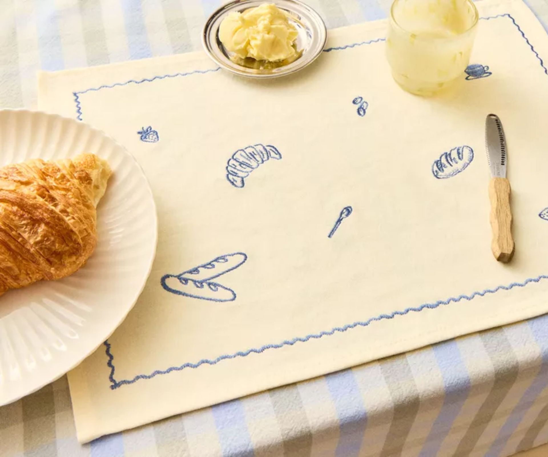 blue gingham tablecloth with a butter yellow embroidered placement with blue brunch motifs