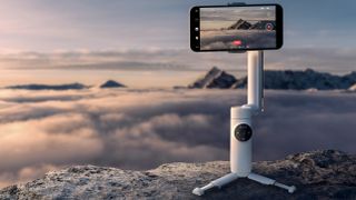 The Insta360 Flow sitting on a mountain in front of clouds