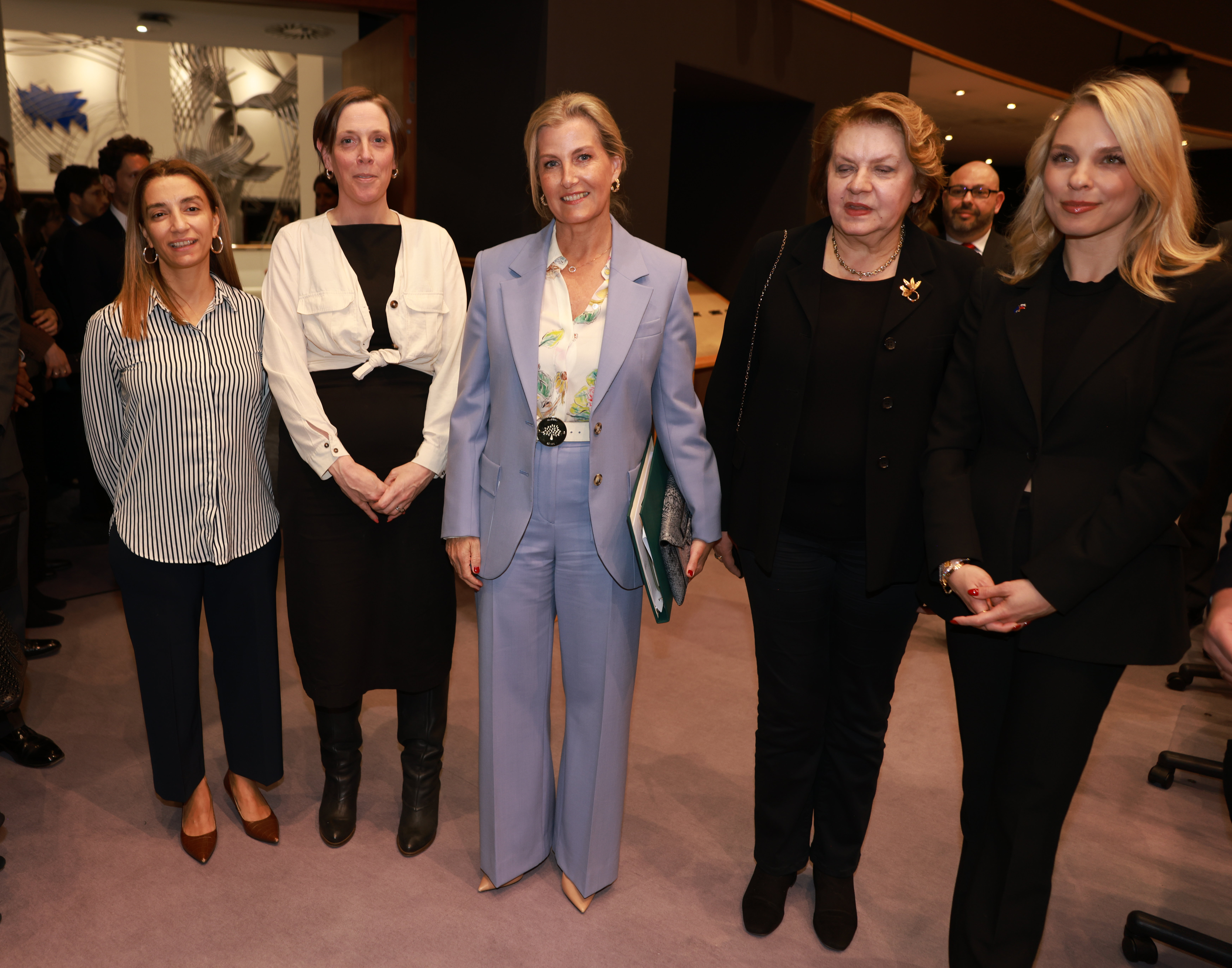 Duchess Sophie wearing a blue suit next to four women in black outifts